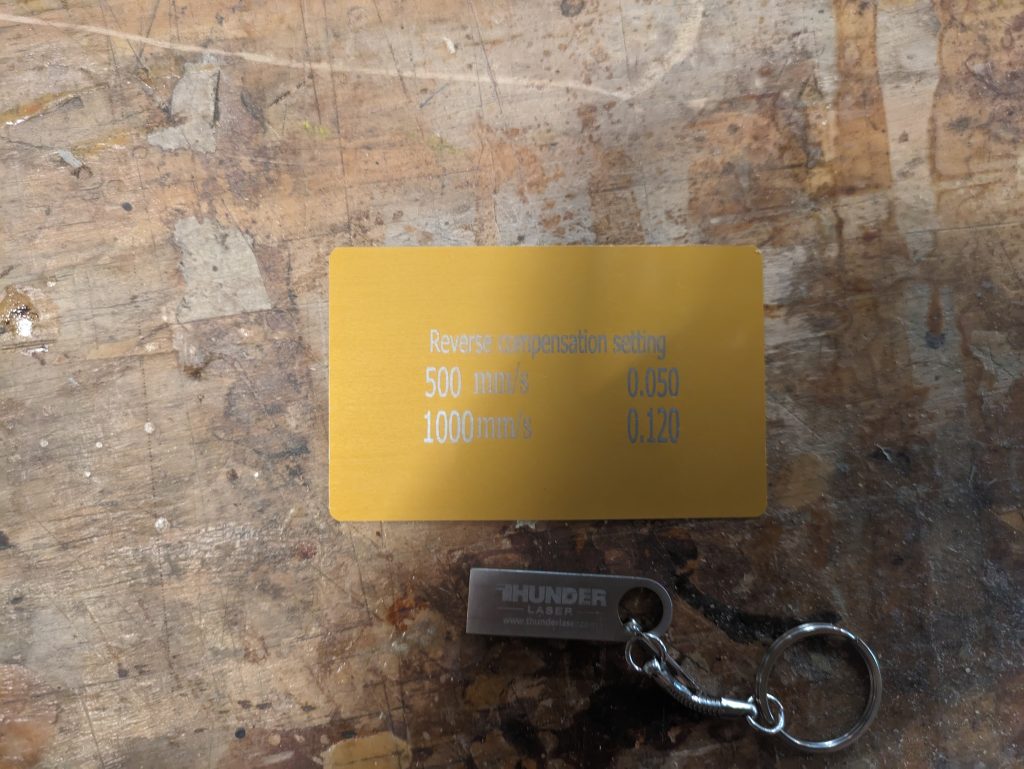 a gold metal gord with scanning offset numbers and a metal usb key.