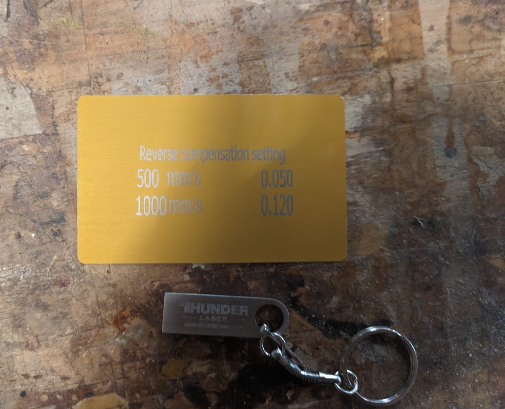 a gold metal gord with scanning offset numbers and a metal usb key.