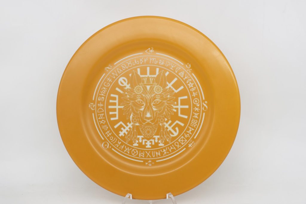 A yellow metal plate with a tribal pattern engraved with a fiber lase engraver