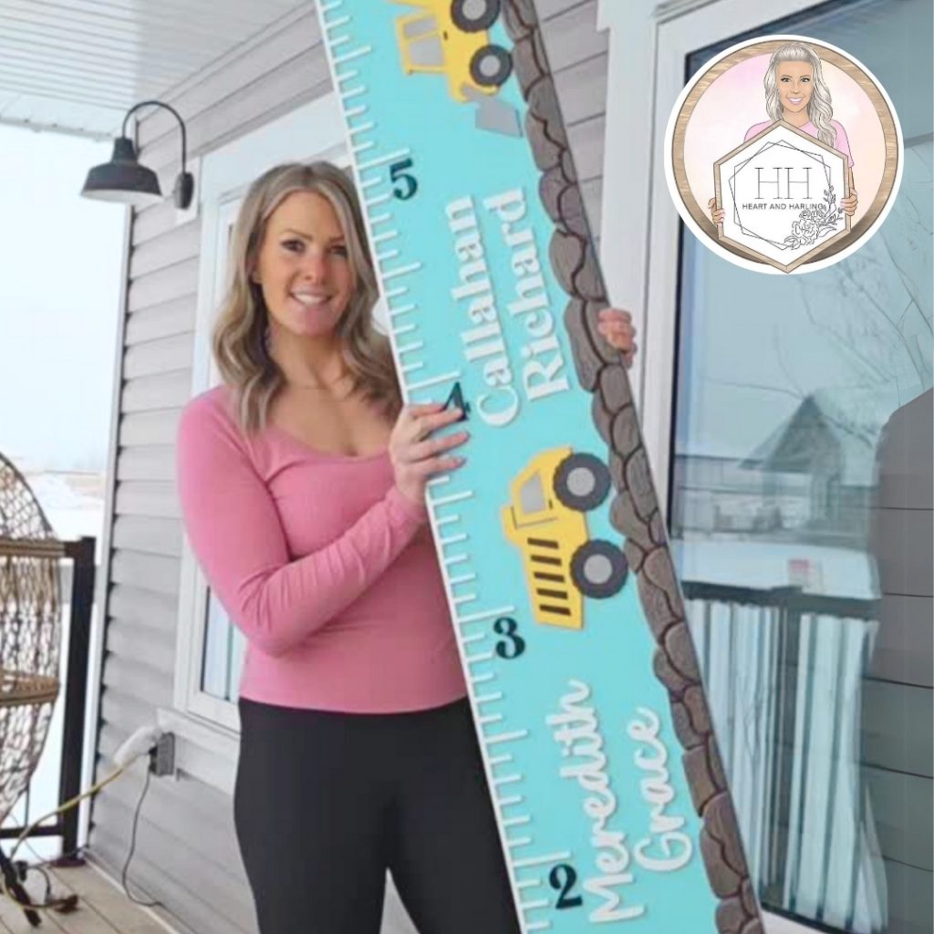 light skinned blond woman is standing on an outdoor porch a large wooden growth chart with yellow dump trucks